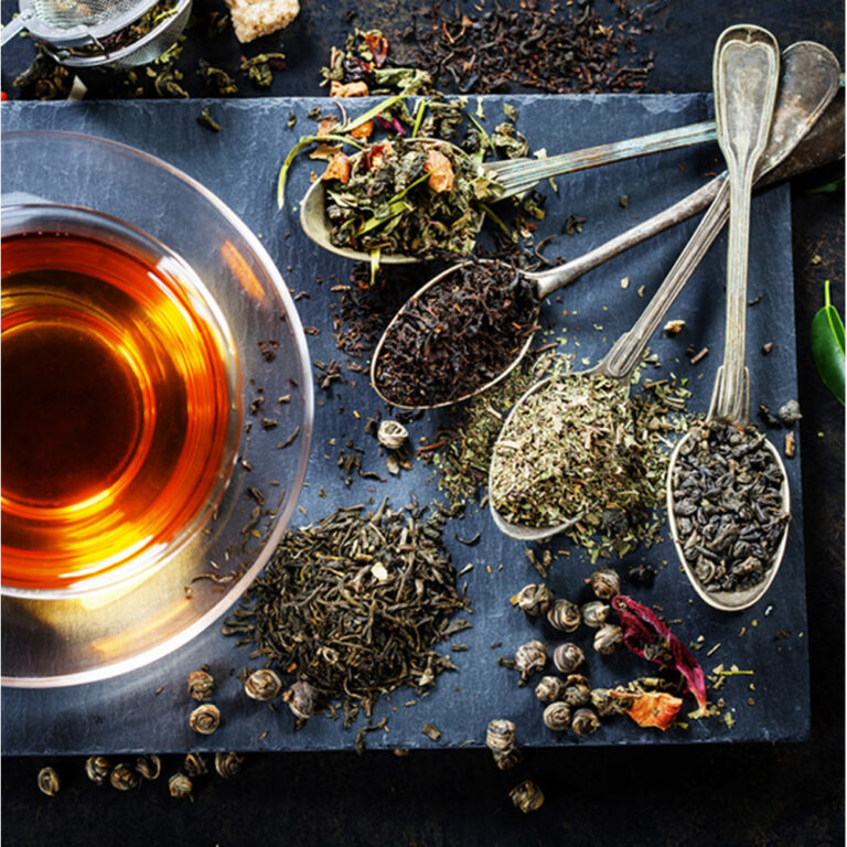 Tea composition with old spoon on dark background